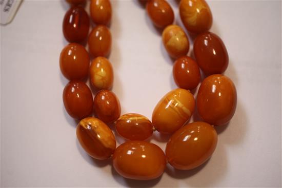 A double strand graduated oval amber bead necklace, gross weight 104 grams.